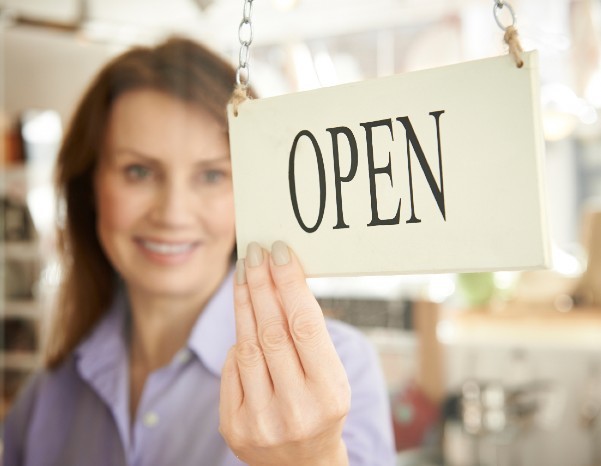 Woman-with-open-sign-CMS