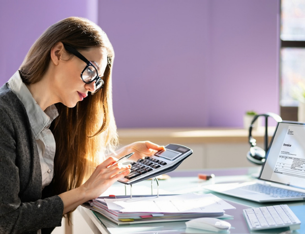 Office worker sat at desk with calculator